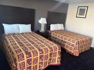 圣安东尼奥Broadway Inn Motel的酒店客房,设有两张床和一盏灯