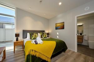 凯库拉Shearwater Apartments的一间卧室配有一张黄色毯子床