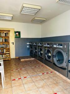 维克拉加尔迪奥勒Mobil-home COSY clim&tv-3 Chambres的一间洗衣房,配有3台洗衣机和瓷砖地板
