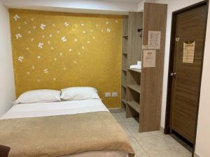 波帕扬Hostel Casa Zambrano的一间卧室设有一张床和黄色的墙壁