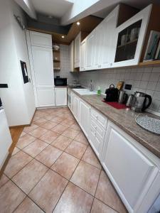 特伦托Ai Cappuccini, Trento a 360 gradi的厨房配有白色橱柜和瓷砖地板。