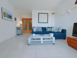 塔马留Precioso apartamento con piscina en Tamariu的客厅配有蓝色的沙发和电视