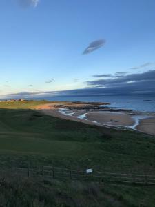 ColinsburghDenburn Cottage, East Neuk of Fife的享有高尔夫球场和大海的景色