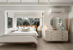 MontecitoPalm Cottage的白色卧室设有一张大床和镜子