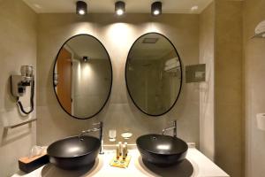 埃尔莫波利斯Hotel Hermes的浴室设有2个水槽和2面镜子