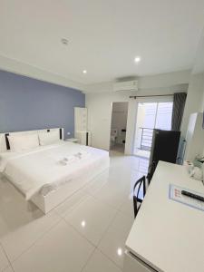 素叻SC Residences的卧室配有白色的床和书桌