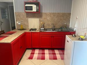 La TontoutaB&B Tontouta的一间带红色橱柜和水槽的厨房