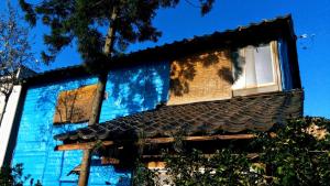 鱼津Gegege no Guesthouse - Vacation STAY 9459的蓝色的建筑,设有两扇窗户和屋顶