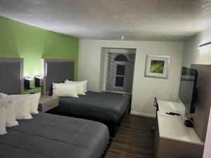圣克鲁兹The Aqua Pacific Hotel的酒店客房设有两张床和一台平面电视。