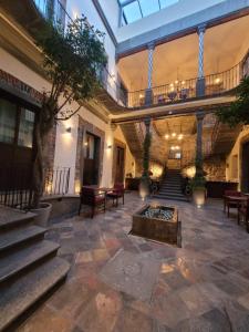 普埃布拉Milo Collection Hotel的一个带楼梯和火坑的大型大堂
