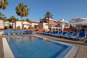 卡勒达德福斯特卡莱塔礁滩酒店的一个带蓝色躺椅和遮阳伞的游泳池