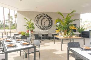 圣维森特The Hotel Elizabeth Resort and Villas - Long Beach San Vicente Palawan的用餐室配有桌椅和植物