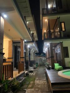蓝梦岛Bima Homestay Lembongan的夜间带游泳池的大楼走廊