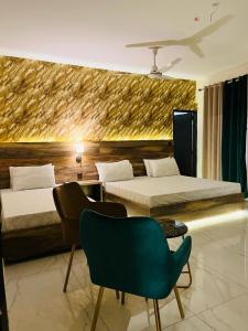 卡拉奇TULIP HOTELS AND APPARTMENTS的酒店客房,设有两张床和一把绿色椅子