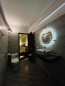 卡拉奇TULIP HOTELS AND APPARTMENTS的一间带卫生间、水槽和镜子的浴室