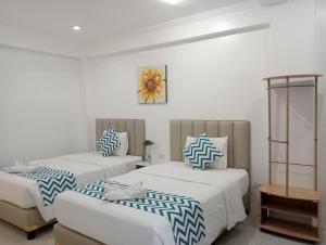 长滩岛碧海蓝天沙滩酒店的一间带两张床和一张沙发的卧室
