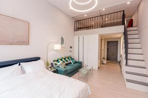 丽水市Ocean Marina Suite View的一间卧室设有一张床、一个楼梯和一张沙发