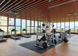 马六甲NEW Cozy Seaview Bali Residences Studio 4pax near Jonker的一个带跑步机和机器的健身房,位于带窗户的房间里