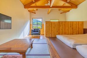 箱根仙石原品之木一之汤旅馆的卧室配有1张床、1张桌子和1把椅子