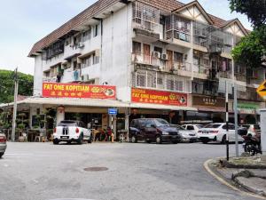 史里肯邦安3 Rooms 2 parking 10pax PSR Comfy Sofa&Bed near MRT Eateries McD的街道前有车辆停放的建筑物