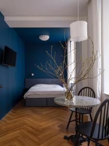 里加MIRO Rooms - quiet chic, free parking, self check-in的卧室拥有蓝色的墙壁,配有桌椅