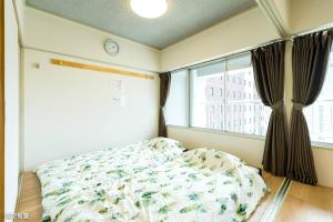 鹿儿岛Nanei Building - Vacation STAY 03606v的一间卧室配有一张床和一个带时钟的窗户