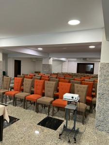 古拉哈莫卢洛伊Hotel Club Bucovina Resort & Spa的一座配有橙色椅子和桌子的空的讲座大厅