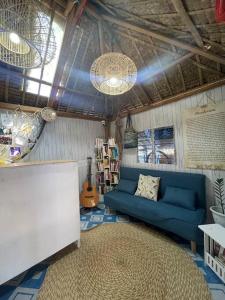 LingayenBeachfront Glamping with Mini Pool Exclusive Property的客厅配有蓝色的沙发和地毯。