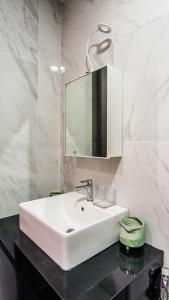 科塔达曼萨拉Emporis SOHO Kota Damansara by Airhost的浴室设有白色水槽和镜子