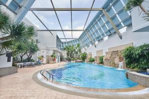 新加坡Adina Serviced Apartments Singapore Orchard的一座带玻璃天花板的建筑中的游泳池
