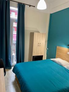 塞萨洛尼基卡斯托瑞亚酒店的蓝色的卧室设有床和窗户