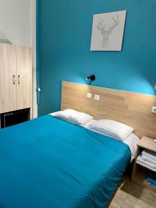 塞萨洛尼基卡斯托瑞亚酒店的蓝色的卧室,配有一张蓝色墙壁的床