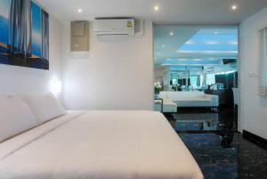 芭东海滩PATONG TOWER FAMILY SEA VIEW by PTA的一间带白色床的卧室和一间客厅