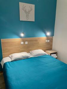 塞萨洛尼基卡斯托瑞亚酒店的一间卧室配有一张蓝色的床和木制床头板
