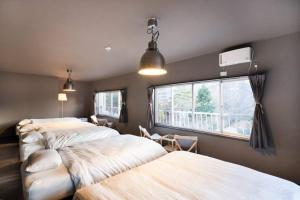 山中湖村tj resort YAMANAKAKO Luxury large villa with Mt. Fuji, Sauna BBQ Max 25的一间卧室设有两张床和窗户。