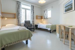 瓦萨EC-Hostel的一间设有两张床和一张桌子及椅子的房间