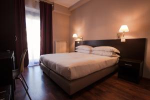 米兰Hotel di Porta Romana的卧室配有一张带白色床单和枕头的大床。