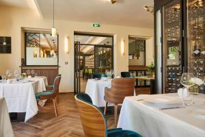 皮利尼蒙特拉谢Olivier Leflaive Hôtel Restaurants的餐厅设有白色的桌椅和窗户。
