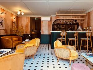 芒通伦敦酒店的一间设有黄色椅子的餐厅和一间酒吧