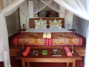 Villa Moringa Lodge的一间卧室配有一张大床和木桌
