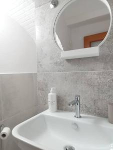米诺利DonPeppeHouse的浴室设有白色水槽和镜子