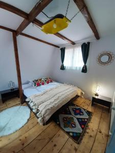 FrăsinetCasa Ele的铺有木地板的客房内设有一间卧室和一张床。