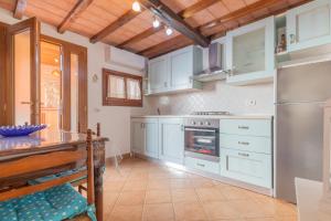 里奥马里纳HelloElba Villetta Fiorita的厨房配有白色橱柜和不锈钢冰箱