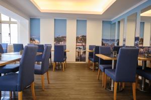 里斯本帕特里亚酒店的餐厅设有蓝色的椅子和桌子以及窗户。