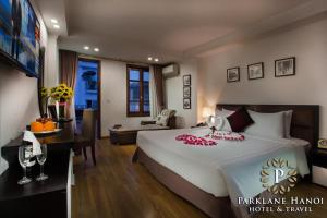 河内Parklane Central Hanoi Hotel的一间带大床的卧室和一间客厅