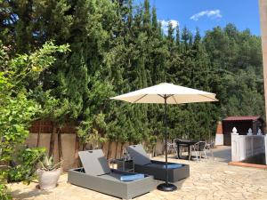 圣埃乌拉利亚Villa Casa Diego Ibiza的庭院配有两把椅子和一把遮阳伞
