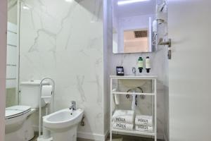 里斯本帕特里亚酒店的白色的浴室设有卫生间和水槽。