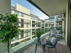 迪拜HiGuests - Charming Retreat in CityWalk With Balcony and Pool的公寓的阳台配有椅子和桌子
