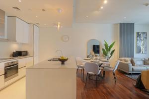 迪拜HiGuests - Charming Retreat in CityWalk With Balcony and Pool的厨房以及带桌椅的起居室。