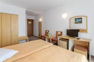 曼加利亚Hotel AquaPark Balada Saturn - ULTRA ALL INCLUSIVE的配有一张床和一张书桌的酒店客房